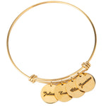 Gold-plated bangle bracelet with three circular charms engraved with names, displayed against a white background