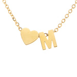 A gold-colored necklace with a heart-shaped pendant featuring the initial 'M' in the center.